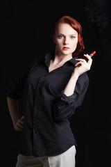 Obraz premium Attractive redhaired young woman holding lipstick like a cigar