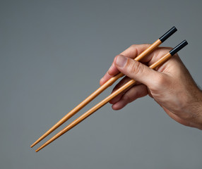 Male hand with  chopsticks.
