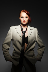 Portrait of the beautiful redhaired girl in men's wear