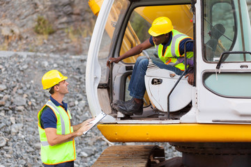 construction foreman talking excavator operator