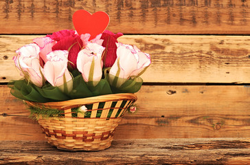 Fototapeta na wymiar Paper flower in a basket over wooden background. Love concept
