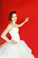 young bride leaning on red wall with copy space