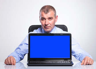 old business man at desk with empty screen laptop