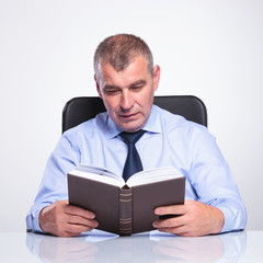 senior business man reads at his desk