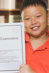 Young asian boy with full score examination sheets