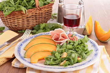 plate of fresh salad with melon,ham and lettuce