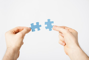 two hands trying to connect puzzle pieces