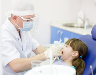 dental examining being given to little girl by dentist