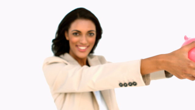 Businesswoman showing piggy bank to the camera