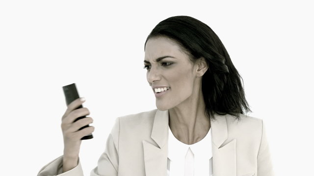 Businesswoman screaming down her mobile phone in black and white