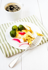 Serving  breakfast with fried cutted egg, black coffee and veget