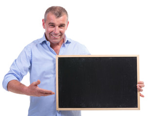 casual middle aged man points at blackboard