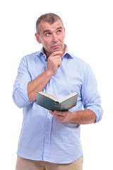 casual middle aged man with book, thinks