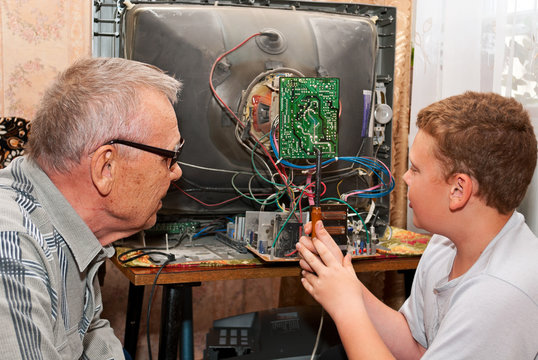 Дедушка и внук чинят старый телевизор