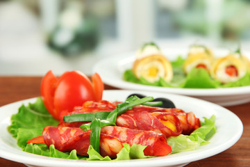 Salami rolls on white plate on bright background