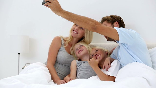 Father taking self portrait of him with happy family