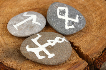Fortune telling  with symbols on stones on wooden background