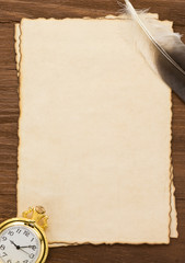 ink feather and watch on parchment background