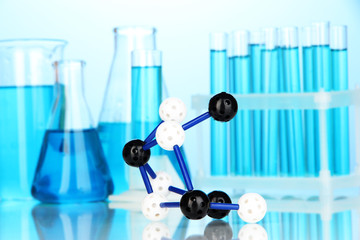 Molecule model and test tubes with liquid on blue background