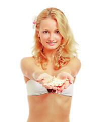 Beautiful woman in bikini giving a seashell