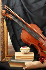 Antique violin, baguette, and book's