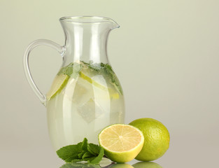 Lemonade in pitcher on green background