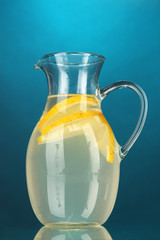 Lemonade in pitcher on blue background