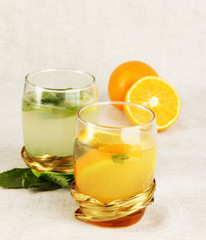Lemonade in glasses on fabric background close-up