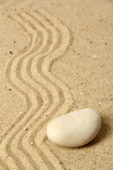 Fototapeta na wymiar Zen garden with raked sand and stone close up