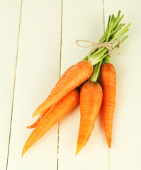 Heap of carrots on color wooden background