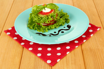 Tasty roasted marrow and tomato slices with salad leaves,