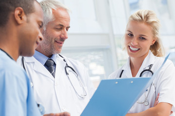 Fototapeta premium Three doctors examining a file