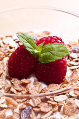 yogurt with muesli and raspberries in small glass 