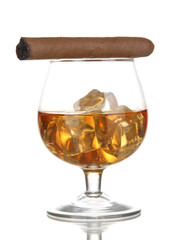 Brandy glass with ice and cigar isolated on white