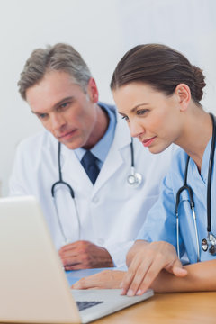 Two doctors focused on a laptop screen