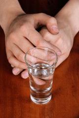 Drunk man drinks vodka at table close-up
