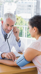 Doctor measuring the blood pressure of his patient