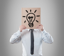 Businessman holding a card with light bulb. Idea concept