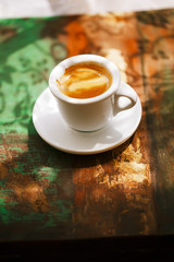 espresso coffee cup on rustic table with sun