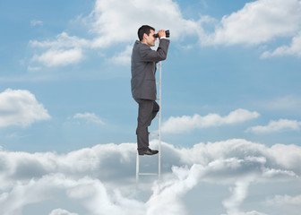 Businessman on ladder over the clouds