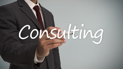 Businessman writing the word consulting with a marker