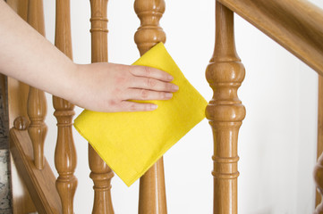 cleaning wooden railing with yellow cloth horizontal