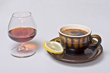 A cup of coffee and a glass of cognac