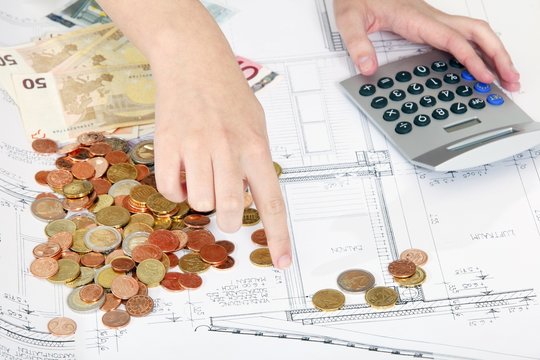 H&auml;nde mit Bauplan, Geld und Taschenrechner