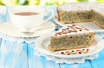Delicious poppy seed cake with cup of tea on table close-up