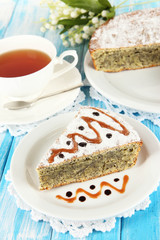Delicious poppy seed cake with cup of tea on table close-up