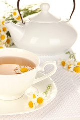Cup of herbal tea with camomiles close up