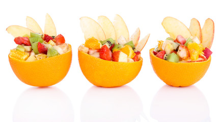 Fruit salad in hollowed-out orange isolated on white
