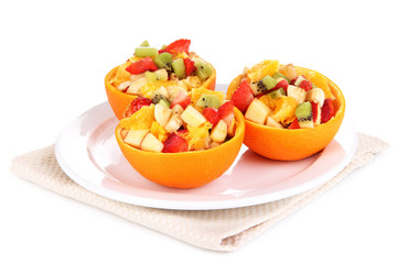 Fruit salad in hollowed-out orange isolated on white