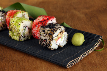 Tasty Maki sushi - Roll on mat on brown background